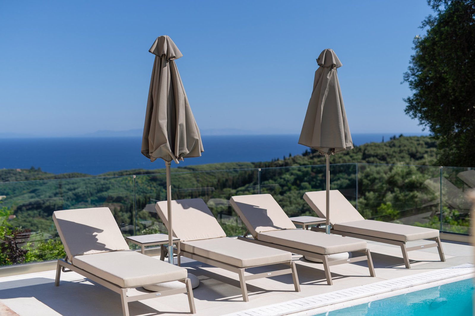 Pool view displaying sunbeds with Ionian sea view in the background